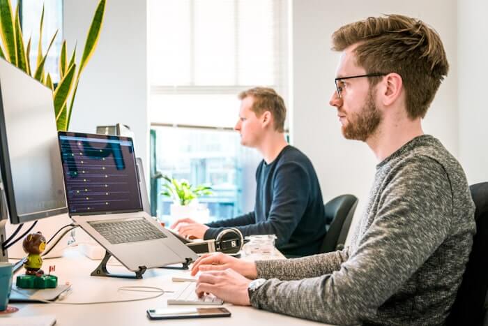 Developers reviewing code on monitors in an office